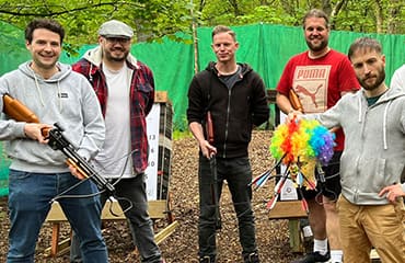 Group of friends posing with crossbows at Adventure Now Manchester